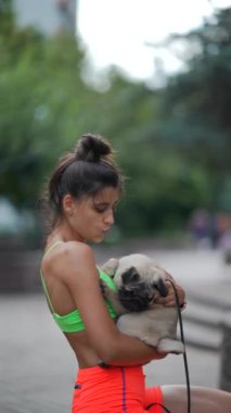 Şehir sokakları spor giysili bir kızın köpeğiyle yürüdüğüne tanıklık ediyor. Yüksek kalite 4k görüntü