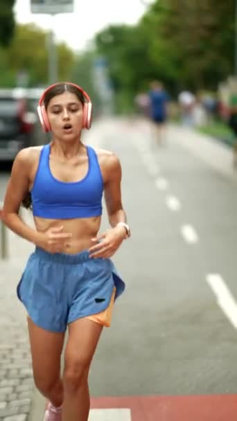 一名身穿运动服的可爱女孩穿着运动耳机 早上在城里慢跑 高质量的4K镜头 — 图库视频影像