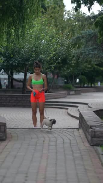 Zaangażowany Spokojny Spacer Ładna Dziewczyna Sportowej Odzieży Towarzyszy Jej Pies — Wideo stockowe
