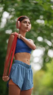 Koşmadan önce, spor kıyafetli genç bir bayan ısınma turu için spor bandı kullanıyor. Yüksek kalite 4k görüntü