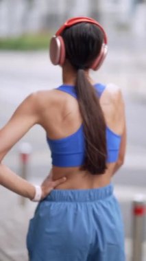 Spor giyimli genç bir kız koşusu sırasında rahatsızlığı nedeniyle karnını tutuyor. Yüksek kalite 4k görüntü