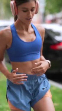 Koşusundan önce, atletik giysili genç bir kız vücut esneme hareketleri yapıyor. Yüksek kalite 4k görüntü