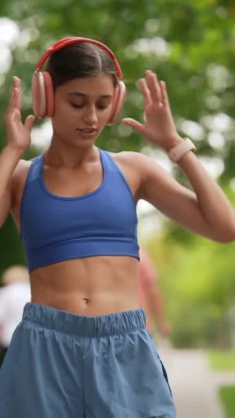 スポーツウェアの若い女性が走る前にスマートフォンを見ています 高品質の4K映像 — ストック動画