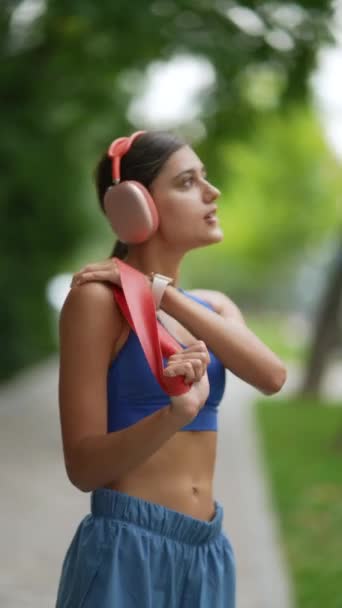 在她慢跑之前 一位穿着运动服的年轻女子正在用一个健身带进行热身运动 高质量的4K镜头 — 图库视频影像