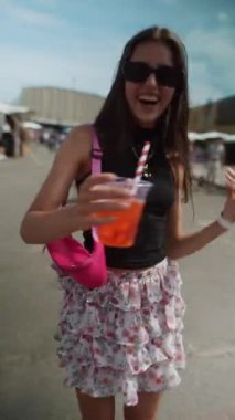 Güneş gözlüğü takan genç bir kadın yaz festivalinde açık havada dans ediyor. Yüksek kalite 4k görüntü