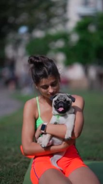 Bir park sahnesinde, genç bir sporcu kadın köpeğini eğlendiriyor. Yüksek kalite 4k görüntü