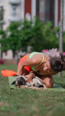 Spor kıyafetli bir kız, sabah antrenmanını parkta yapıyor, köpeğiyle oyun zamanını da içeriyor. Yüksek kalite 4k görüntü