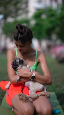 Parkta biraz eğlenen genç bir kadın, köpeğiyle etkileşime geçiyor. Yüksek kalite 4k görüntü