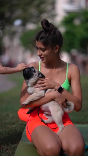 若いアスレチックな女の子が公園でパグ犬と遊んでいる 高品質の4K映像 — ストック動画