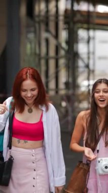 Şehrin sokaklarında, iki yoldaş bavullar ve çantalarla yürürken sohbet ediyorlar. Yüksek kalite 4k görüntü