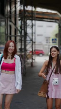 Bavulları ve çantaları olan iki enerjik genç arkadaş şehir sokaklarında yürüyor. Yüksek kalite 4k görüntü