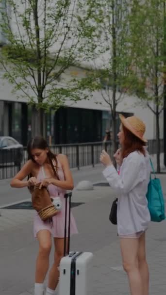 两个带着袋子和手提箱的漂亮的年轻女子正在城市的街道上交谈 高质量的4K镜头 — 图库视频影像