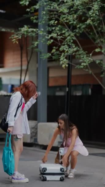 Şehrin Tam Ortasında Iki Çekici Genç Bayan Sokaktaki Valizlerinden Eşyalarını — Stok video