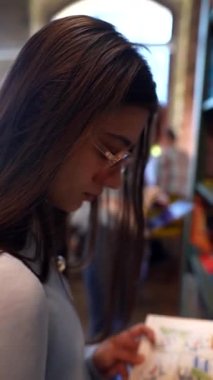 Kütüphanede kitabı olan genç ve güzel bir kadın. Yüksek kalite 4k görüntü