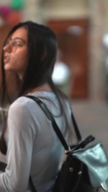 Güzel bir kız kitapçıda rahatça yürüyor, etrafı kitaplarla çevrili. Yüksek kalite 4k görüntü