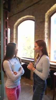 Kitap sıralarının arasında, iki güzel arkadaş kütüphanede bir kitapla görüldü. Yüksek kalite 4k görüntü