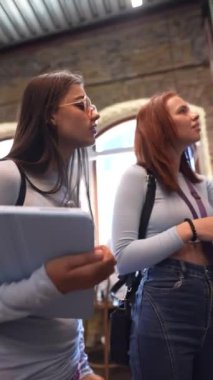 Kitap sıralarının arasında, iki çekici ve genç arkadaş kitapçıda meseleleri tartışıyor. Yüksek kalite 4k görüntü