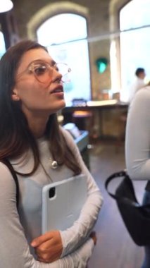 Kitapçıların sessizliğinin ortasında, iki güzel genç bayan sohbete dalıyorlar. Yüksek kalite 4k görüntü