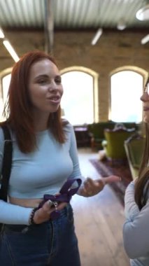 Kitapçıda, iki genç ve çarpıcı arkadaş sohbet ediyorlar. Yüksek kalite 4k görüntü