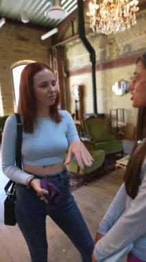 Kitapların arasında, iki güzel ve genç bayan kitapçıda tartışıyorlar. Yüksek kalite 4k görüntü