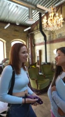 Kitapların arasında, iki güzel ve genç bayan kitapçıda tartışıyorlar. Yüksek kalite 4k görüntü