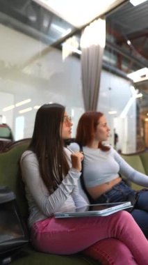 Kitapçıda iki çekici genç kadın konuşurken görülüyor. Yüksek kalite 4k görüntü