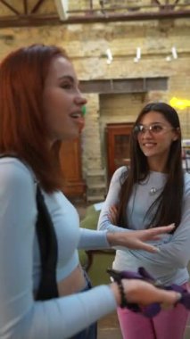 Kütüphanenin huzurlu ortamında, iki genç ve güzel bayan karşılıklı konuşuyordu. Yüksek kalite 4k görüntü