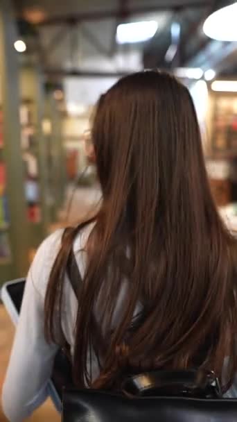 一个惊艳的年轻女子被书环抱着 悠闲地在书店里徘徊 高质量的4K镜头 — 图库视频影像