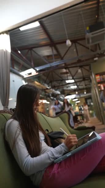 Μια Όμορφη Νεαρή Γυναίκα Κάθεται Έναν Καναπέ Στη Βιβλιοθήκη Υψηλής — Αρχείο Βίντεο