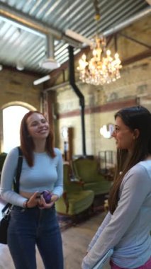 Kitapçıda iki çekici genç kadın konuşurken görülüyor. Yüksek kalite 4k görüntü