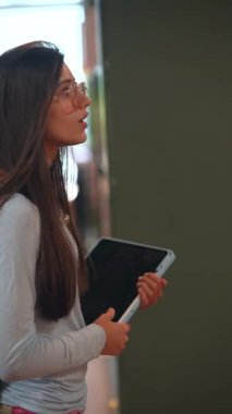 Genç ve enerjik bir kız kitapçıdaki kitaplıklar arasında dolaşırken görülüyor. Yüksek kalite 4k görüntü