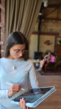 Elinde bir tabletle, sevimli genç bir bayan kitapçıdan bahsediyor. Yüksek kalite 4k görüntü