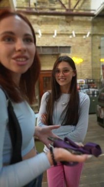 Kütüphanenin huzurlu ortamında, iki genç ve güzel bayan karşılıklı konuşuyordu. Yüksek kalite 4k görüntü