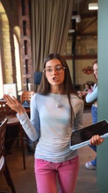 Elinde tabletle güzel bir bayan kitapçıdan bahsediyor. Yüksek kalite 4k görüntü