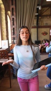 Her ikisi de güzel olan iki genç kadın, elinde tablet olan bir kitapçı hakkında sohbet ediyorlar. Yüksek kalite 4k görüntü