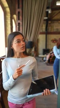 Elinde tabletle genç ve güzel bir kadın kitapçıdan bahsediyor. Yüksek kalite 4k görüntü