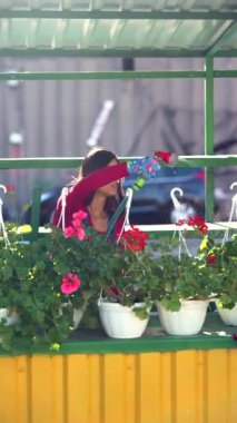 Genç bir kadın marketteki vazolara su püskürtüyor. Yüksek kalite 4k görüntü