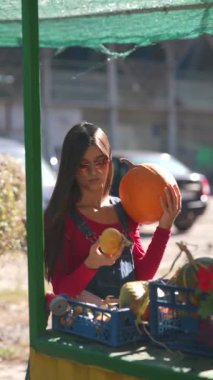 Tedarikçi olarak çalışan muhteşem bir kadın, markette sattığı bitki ve balkabaklarını dikkatlice suluyor. Yüksek kalite 4k görüntü