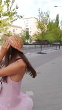 Zarif, kamera kullanan, şapkalı genç bir kız sokaklarda aylak aylak dolaşıyor. Yüksek kalite 4k görüntü