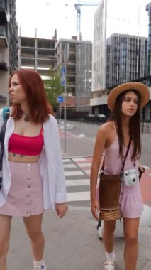 İki dinamik genç kadın ellerinde bavulları ve eşyaları ile şehrin sokaklarında geziniyor. Yüksek kalite 4k görüntü