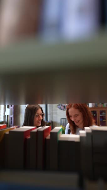 Rodeadas Por Ambiente Las Bibliotecas Dos Chicas Atractivas Jóvenes Conversan — Vídeo de stock