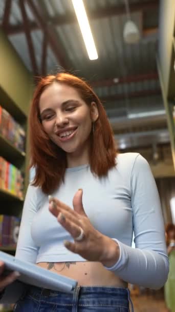 Könyvtár Csendes Légkörében Egy Vonzó Fiatal Hölgy Egy Tablettel Beszélgetésbe — Stock videók