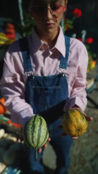 在繁华的市场上 一位女农场主骄傲地展示着一只绿色条纹南瓜 准备出售 高质量的4K镜头 — 图库视频影像