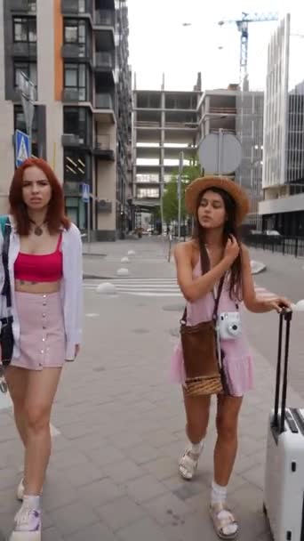 Twee Stralende Jonge Meisjes Slenteren Door Straten Met Een Koffer — Stockvideo