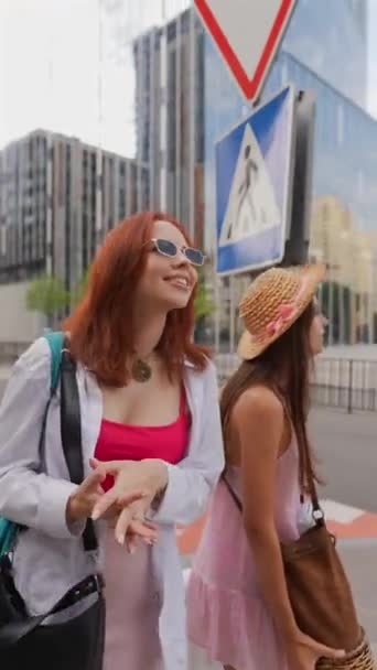2人の活気に満ちた若い女性が スーツケースと持ち物を持って街の通りを歩いています 高品質の4K映像 — ストック動画