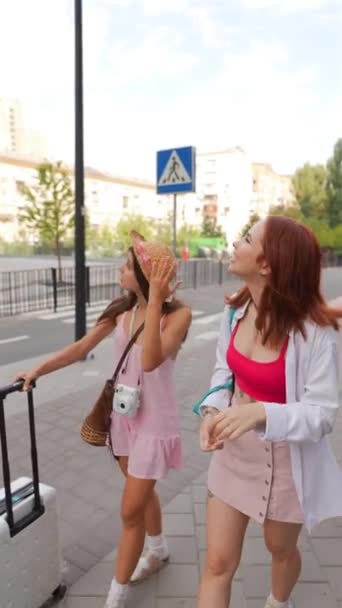 放射性の若い女性は スーツケースと財産を持って 都市の通りを散歩を楽しんでいます 高品質の4K映像 — ストック動画