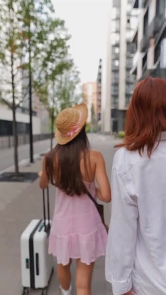 两个充满活力的年轻女子带着一个手提箱和她们的财物在城市的街道上散步 高质量的4K镜头 — 图库视频影像