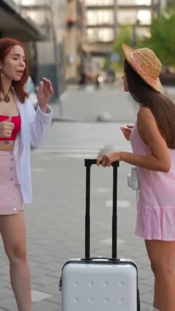 Две Сияющие Молодые Девушки Прогуливаются Улицам Города Чемоданом Вещами Высококачественные — стоковое видео