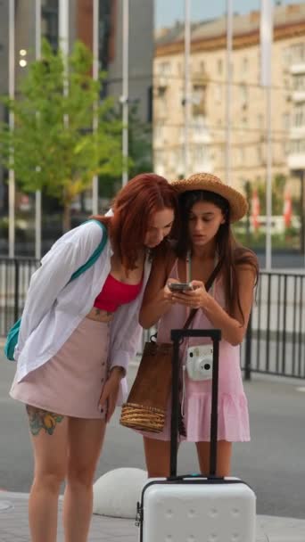 两名充满活力的年轻女孩背着行李 在城市街道上穿梭 用她们的智能手机追踪理想的地址 高质量的4K镜头 — 图库视频影像