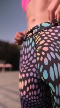 Arkadan, sporcu kılığındaki zarif bir bayan şehir sokaklarında ısınma turu düzenliyor. Yüksek kalite 4k görüntü